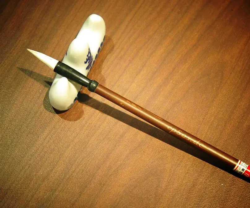 A calligraphy brush resting on its stand