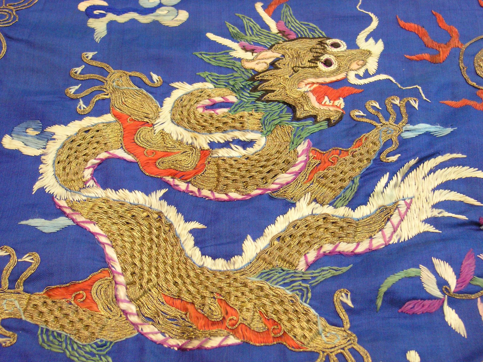 Dragon and cloud embroidery detail on a blue robe